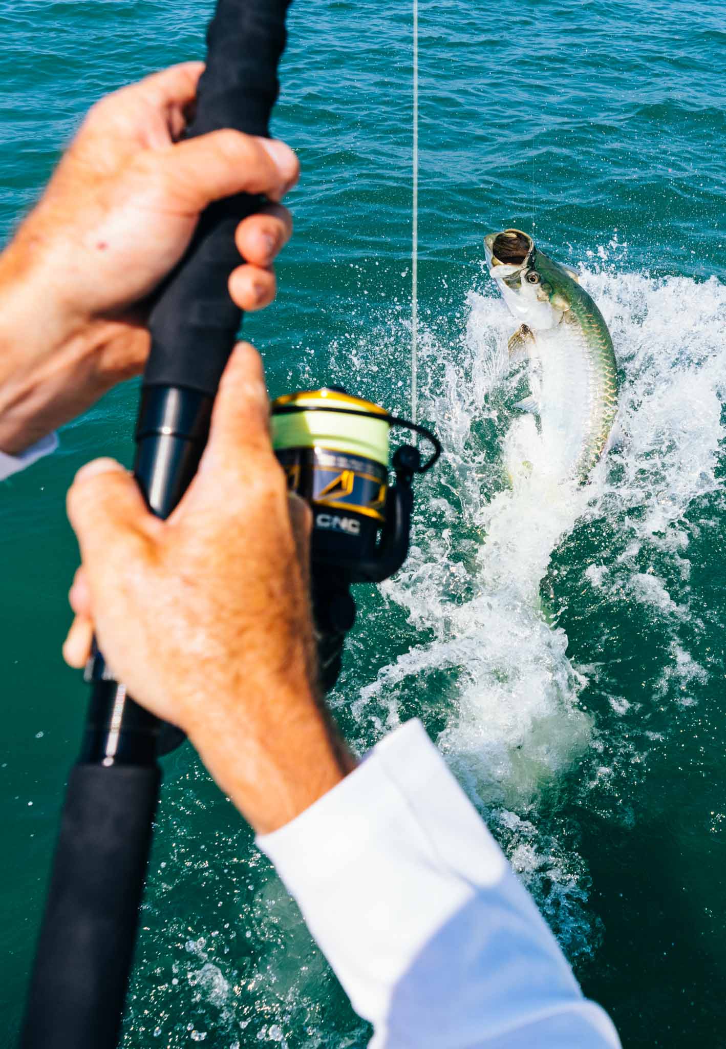Man fishing and fish jumping out of the water