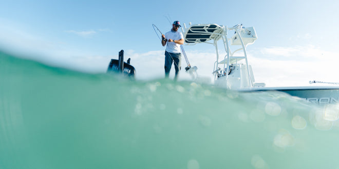Man fishing on a boat and a large wave