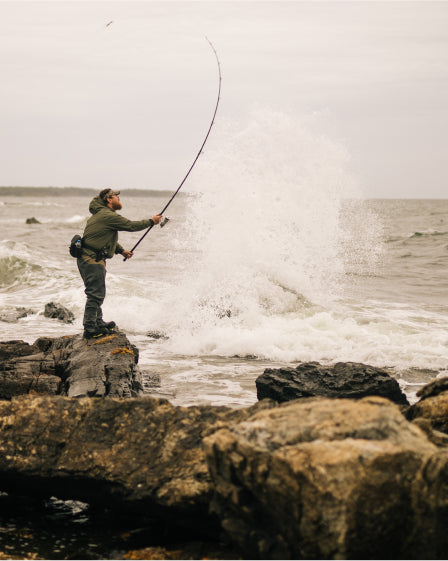 Men fishing over rocks